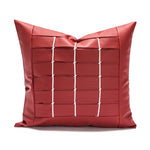Oreiller décoratif en cuir rouge avec motif quadrillé, élément de design d'intérieur moderne et élégant.