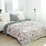 Couverture légère d'été en gaze de coton dépliée sur un lit