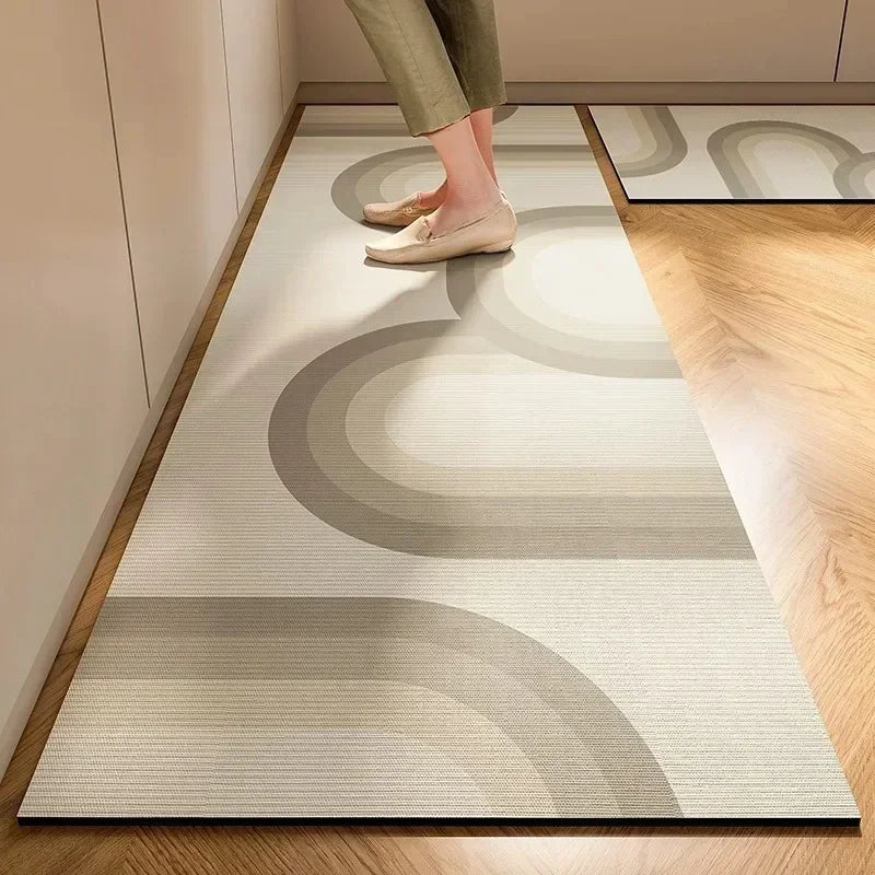 Tapis moderne de design abstrait avec des formes géométriques beiges et grises sur un sol en bois dans une pièce lumineuse.