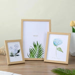 Cadre photo en bois A4 blanc posé sur une table