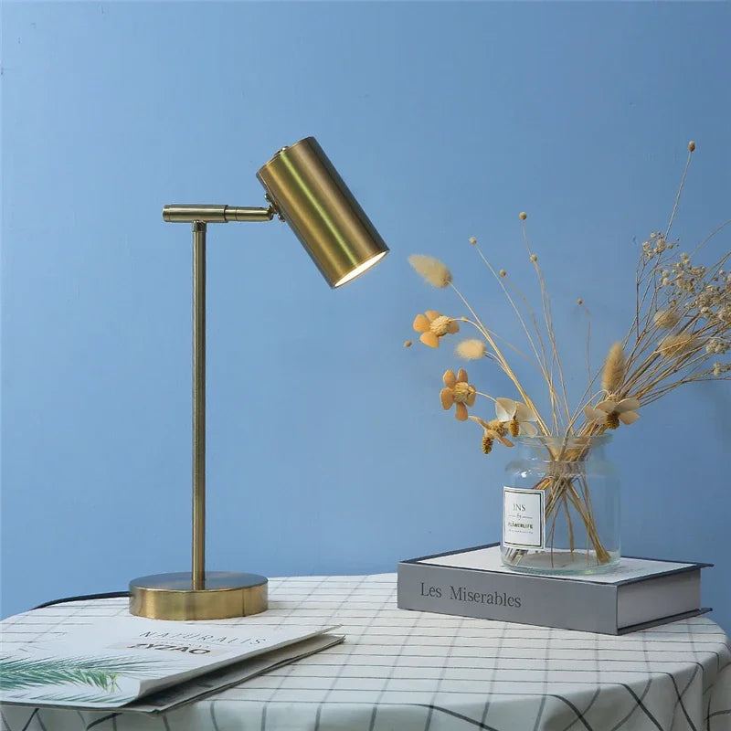 Lampe de chevet dorée allumée offrant un éclairage doux pour la lecture