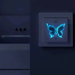 Autocollant papillon lumineux bleu appliqué sur interrupteur de chambre