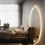 Applique murale LED minimaliste en cercle noir éclairant un salon moderne