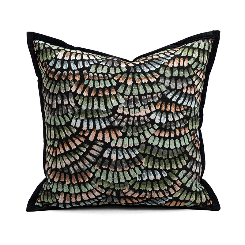 Coussin décoratif avec des motifs géométriques et abstraits dans des tons de vert, beige et noir, créant un design élégant et dynamique.