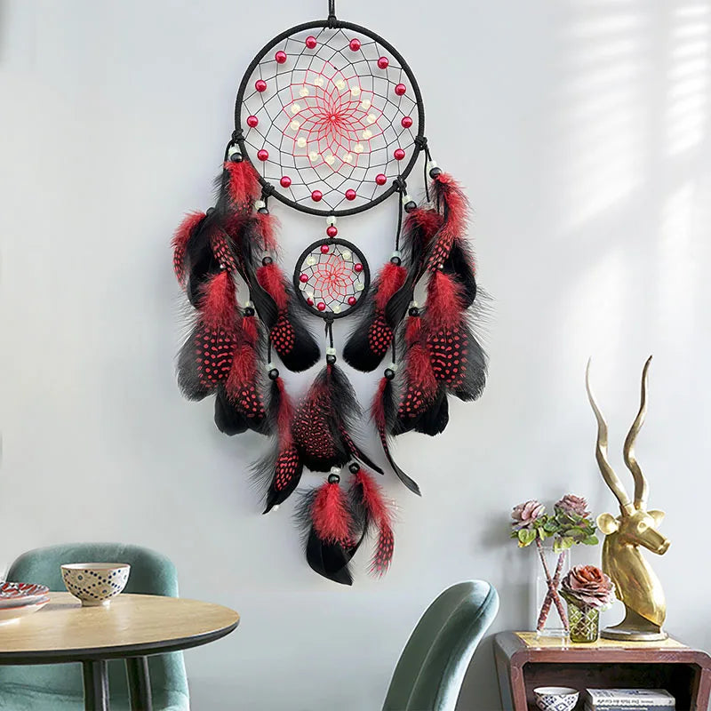 Suspension murale décorative aux couleurs rouge et noire, composée de plumes et d'un motif de capteur de rêves aux motifs floraux.