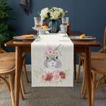 Une élégante composition de table avec des verres de cristal, des assiettes décorées et un bouquet de fleurs blanches créant une ambiance chaleureuse et raffinée.