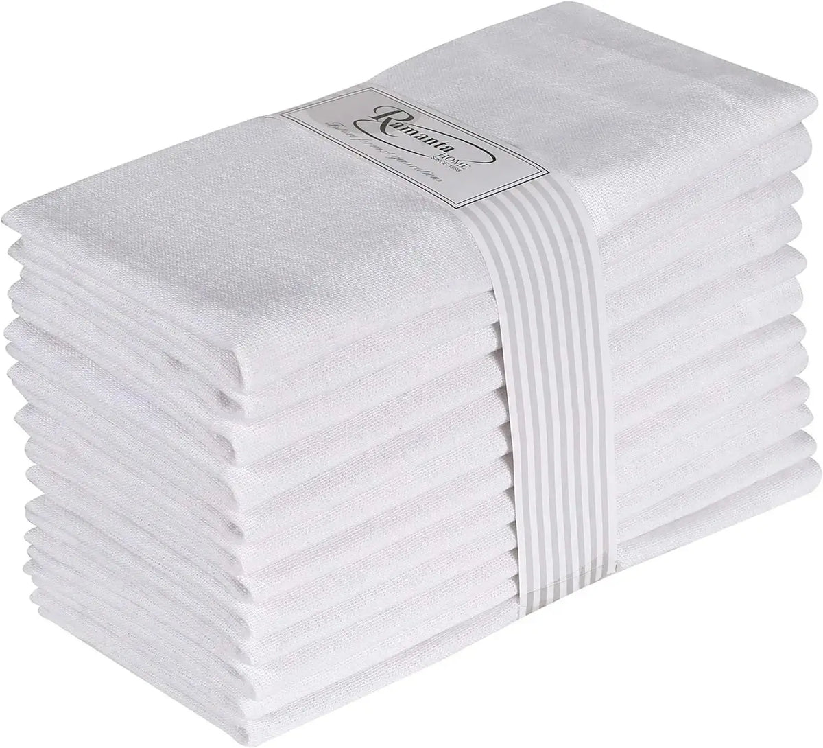 Un ensemble de serviettes de bain blanches et duveteuses empilées avec une étiquette décorative sur le dessus.
