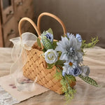 Panier en rotin utilisé comme cache-pot pour fleurs en soie