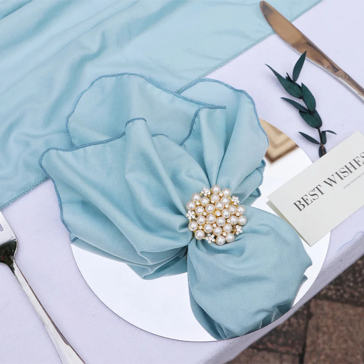 Une belle fleur bleue en tissu avec une broche de perles est posée sur un livre intitulé "Best Wishes".