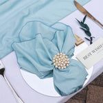 Une belle fleur bleue en tissu avec une broche de perles est posée sur un livre intitulé "Best Wishes".