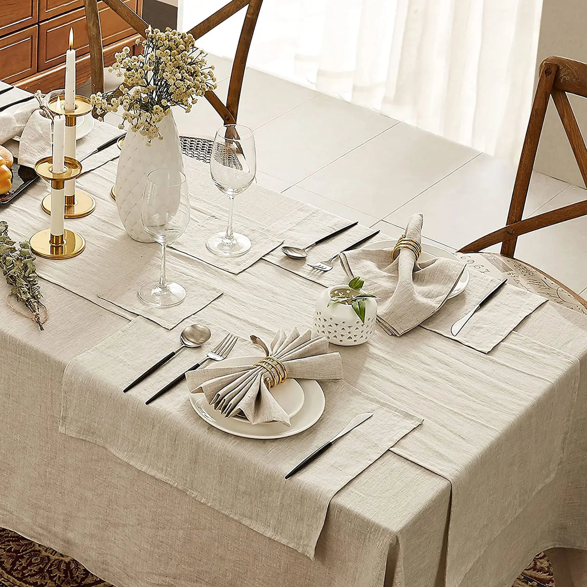Une table élégamment dressée avec des fleurs, des verres et des couverts, créant une atmosphère chaleureuse et accueillante.