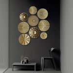 Décoration murale ronde dorée accrochée sur un mur de salon