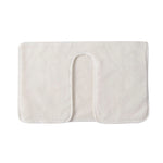 Tapis de bain en tissu doux de couleur crème avec un design minimaliste et une texture douce.