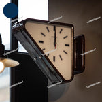 Horloge murale triangulaire double face en métal silencieuse sur un mur blanc