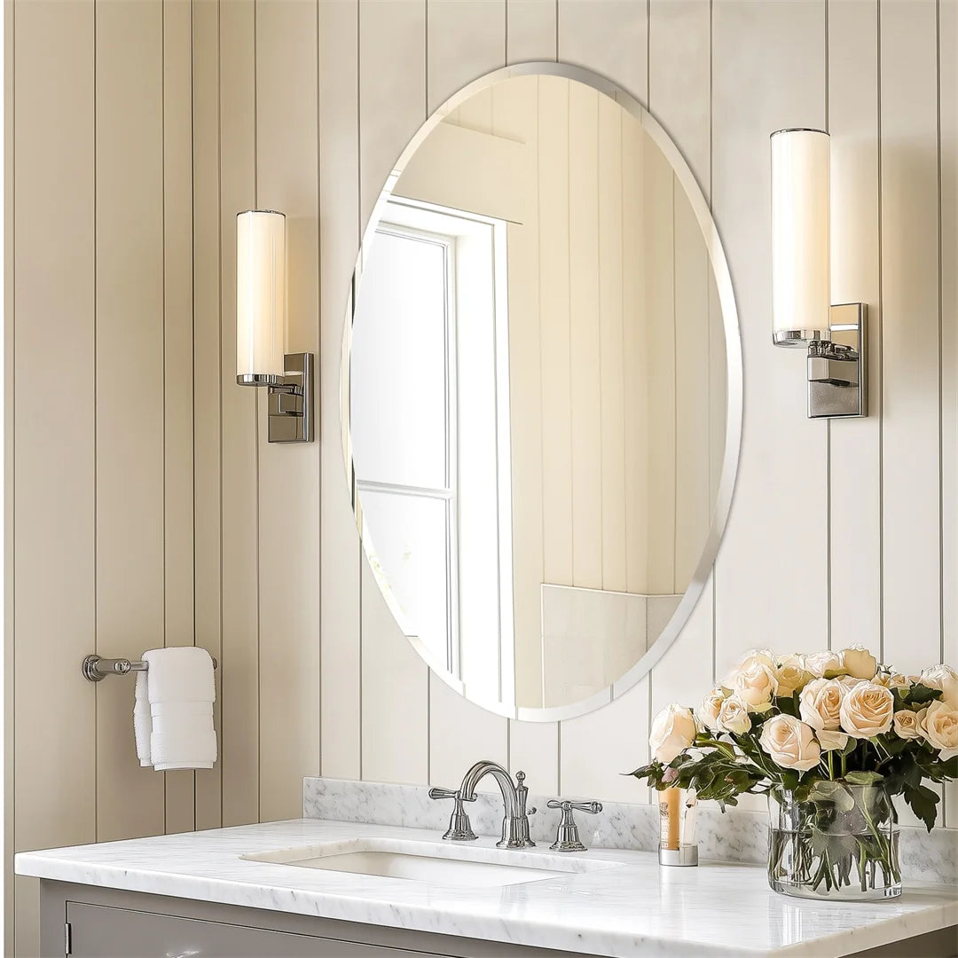 Miroir ovale élégant avec appliques d'éclairage dans une salle de bain luxueuse, avec un évier en marbre blanc et un bouquet de roses beiges.