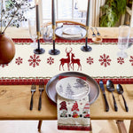Une décoration de table festive avec des motifs hivernaux et des bougies, sur un plan de travail en bois, créant une atmosphère chaleureuse et accueillante pour le temps des fêtes.