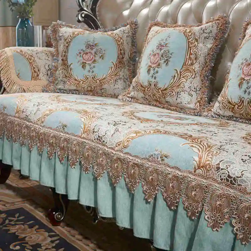 Un canapé orné de motifs floraux élégants dans des tons de vert et beige, avec des ornements dorés sur les accoudoirs et le dossier, créant une ambiance luxueuse et raffinée.