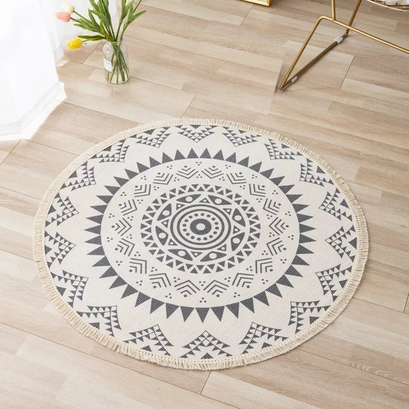 Un tapis rond décoratif en noir et blanc avec un motif mandala géométrique ornemental sur un sol en bois clair.