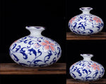Deux magnifiques vases en céramique blanche décorés de motifs floraux bleus et rose vif, posés sur un support en bois sombre, offrant une belle combinaison de couleurs et de textures.