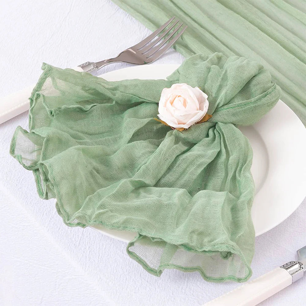 La serviette verte texturée avec une rose blanche posée sur une fourchette suggère une atmosphère élégante et sereine.