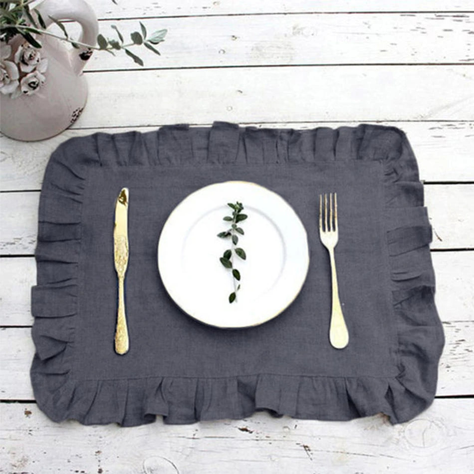 Cette image présente une assiette blanche avec des herbes vertes posée sur un set de table gris clair sur un fond en bois blanc.