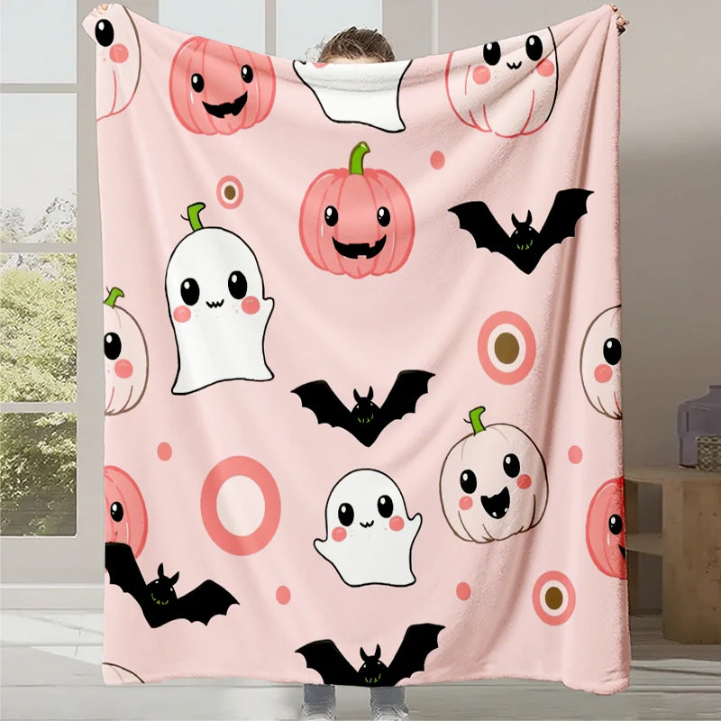Cette couverture douce et douce montre une variété d'éléments décoratifs d'Halloween tels que des citrouilles, des fantômes et des chauves-souris sur un fond rose pastel, créant une ambiance festive et adorable pour la saison.
