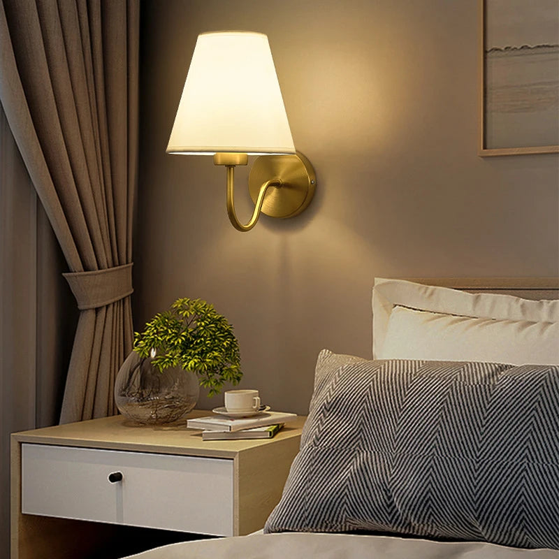 Lampe murale tissu doré éclairée dans une chambre à coucher