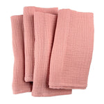 Des serviettes de bain en lin rose pâle, douces et texturées, offrant une expérience de luxe dans la salle de bain.