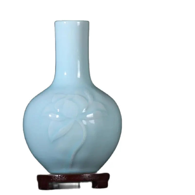 Vase en porcelaine bleu pâle avec un motif de fleur stylisé.