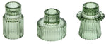 Trois photophores en verre vert laqué aux motifs géométriques.