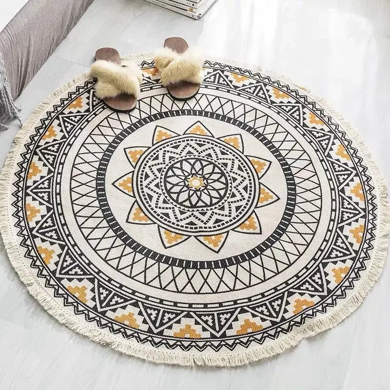 Tapis rond orné d'un motif géométrique traditionnel aux couleurs neutres, avec des pompons décoratifs au bord.