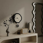 Horloge murale design irrégulière blanche sur mur gris