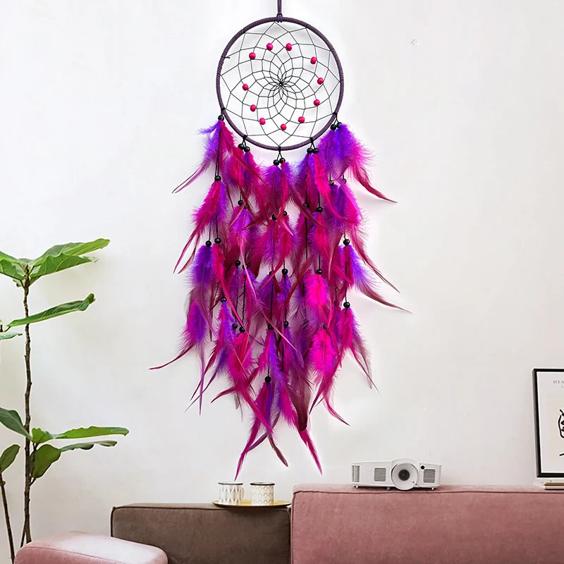 Un magnifique attrape-rêves aux plumes pourpres et roses, suspendu dans un salon décoré avec goût.