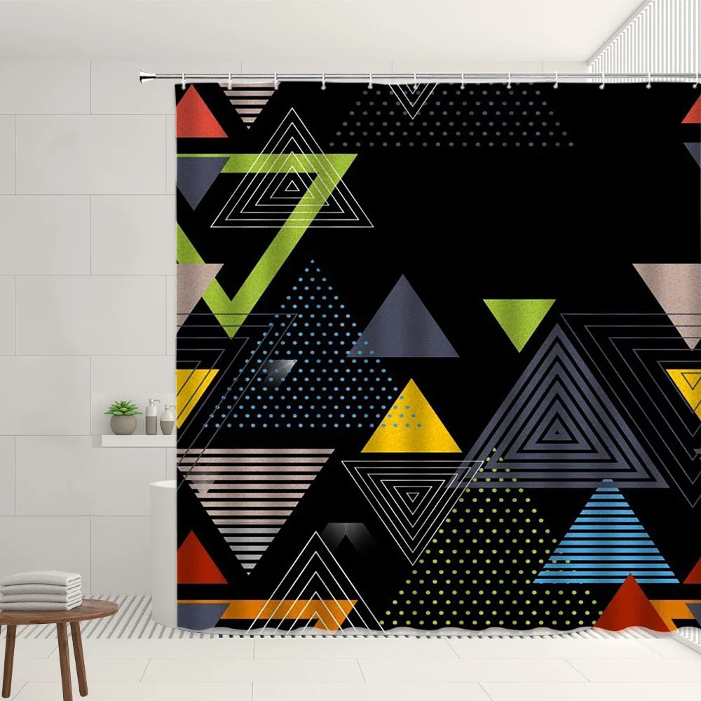 Rideau de douche au design géométrique moderne avec un fond noir mettant en valeur un motif de triangles de différentes tailles et couleurs, dont du vert, du jaune, du bleu et du beige. Certains triangles sont remplis de motifs à rayures, à pois ou en dégradé, ajoutant une touche artistique et dynamique. Installé dans une salle de bain au style épuré avec des carreaux blancs, ce rideau apporte une ambiance contemporaine et audacieuse.