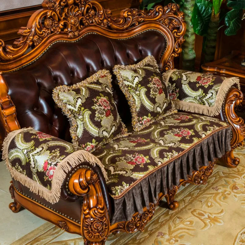 Un canapé en bois sculpté avec des ornements dorés, recouvert de coussins aux motifs floraux vintage.