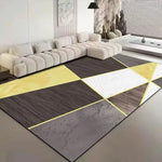 Tapis moderne à motif géométrique en noir, gris et jaune dans un salon avec canapé blanc.