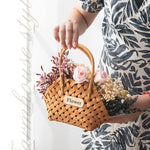 Composition florale dans un panier rotin sur table en bois