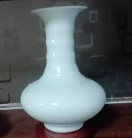Vase en porcelaine blanche à forme élancée.
