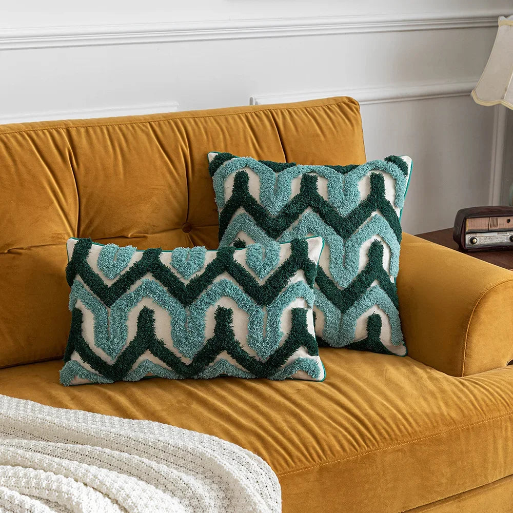 Coussins décoratifs bleu-vert et jaune moutarde sur un canapé doré, créant une ambiance chaleureuse et élégante dans cette pièce.