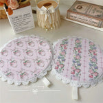 Set de table imperméable rose posé sur une nappe blanche