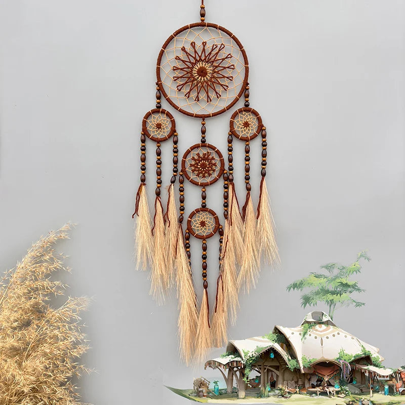 Un rêve capteur suspendu aux tons terracotta et beige, avec des motifs en forme d'étoile et des franges délicates, créant une atmosphère apaisante et artisanale.