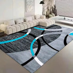 Un tapis moderne avec des motifs géométriques abstraits en noir, blanc et bleu, qui crée une ambiance élégante et dynamique dans ce salon.