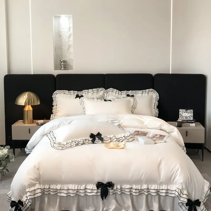Housse de couette blanche à volants multicouches avec nœuds papillon sur lit