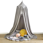 Lit baldaquin gris élégant avec décoration murale et accessoires confortables, créant un espace cocooning intime et relaxant.