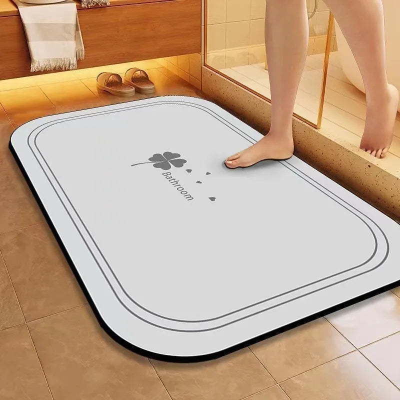 Un tapis de bain blanc avec un motif trèfle sur une surface carrelée dans une salle de bain moderne.