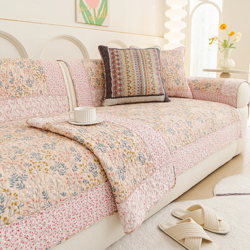 Un canapé confortable et douillet, décoré d'un joli motif floral aux couleurs pastel, créant une atmosphère chaleureuse et accueillante dans cette pièce lumineuse.