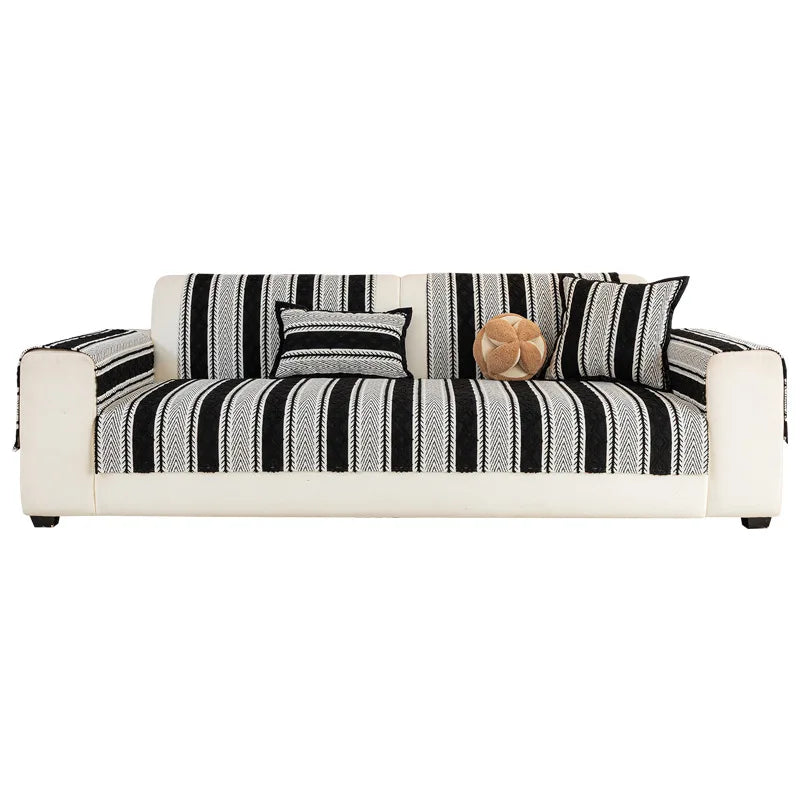 Un canapé moderne et élégant avec des rayures noires et blanches, orné de coussins décoratifs.