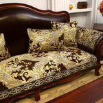 Un canapé ancien de style victorien à l'aspect élégant et luxueux, décoré de motifs floraux dorés sur un fond sombre, créant une atmosphère chaleureuse et sophistiquée dans l'espace.