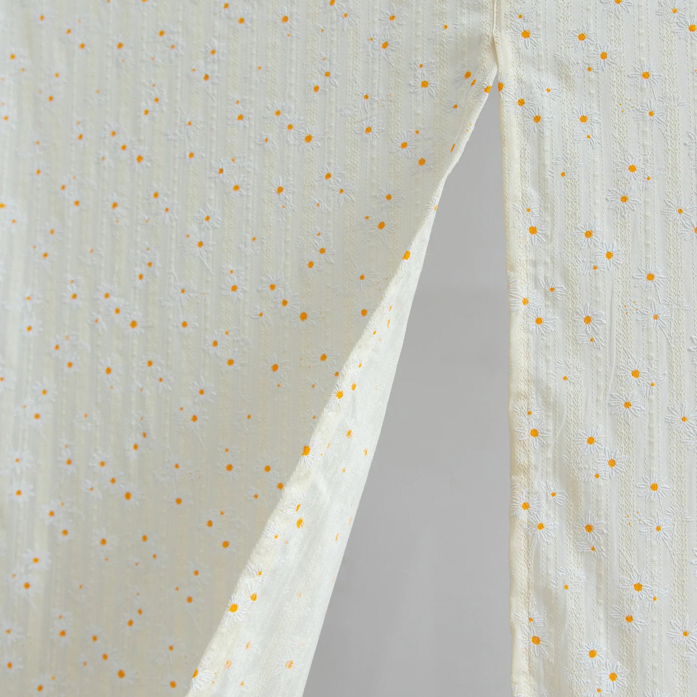 Détail du motif floral lilas et des franges sur le rideau