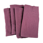 Un ensemble de serviettes de bain en tissu doux et texturé de couleur bordeaux.